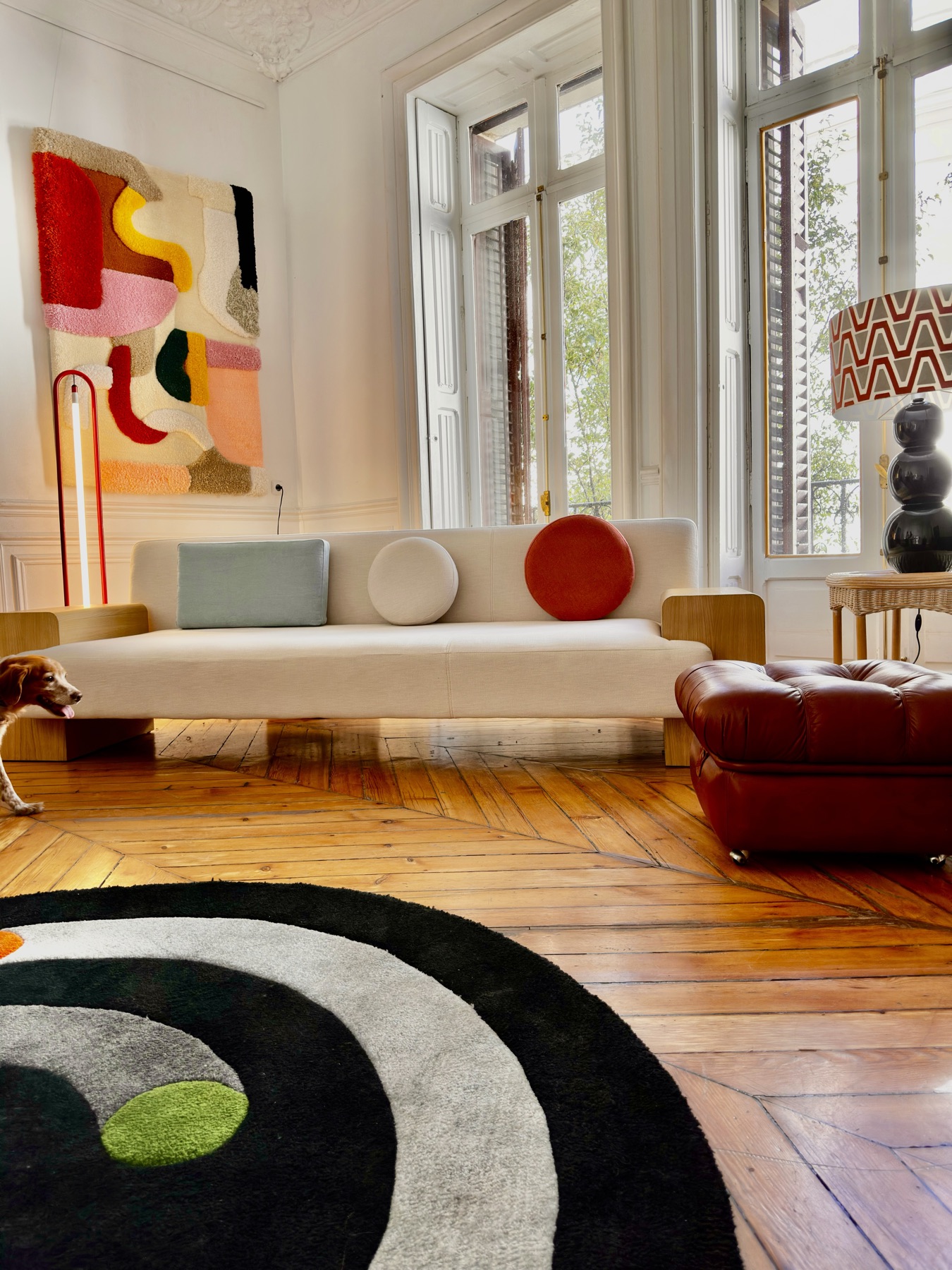 Salón con sofá blanco, tapiz textil de colores y alfombra circular