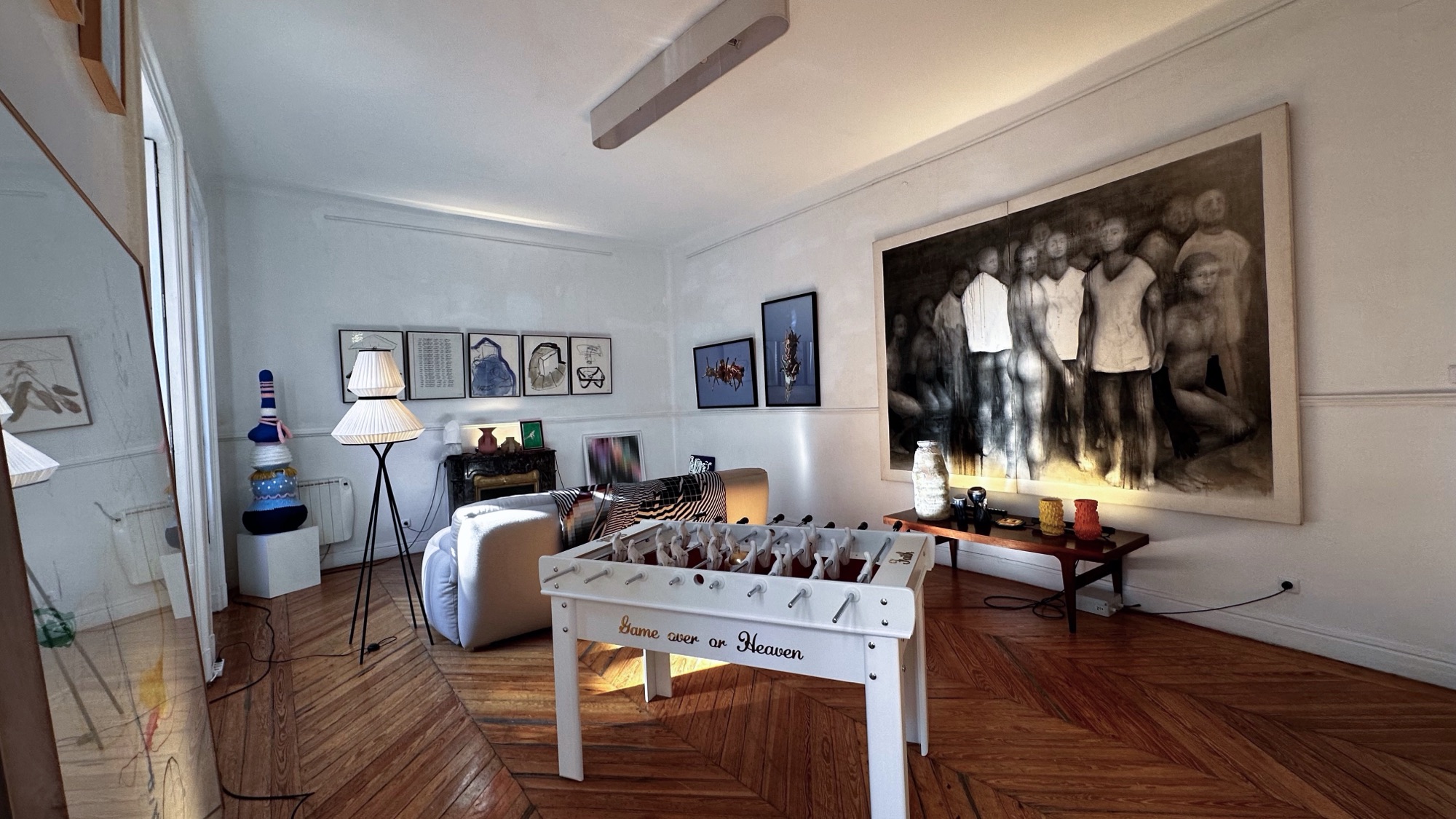 Sala con futbolín blanco y gran dibujo en blanco y negro